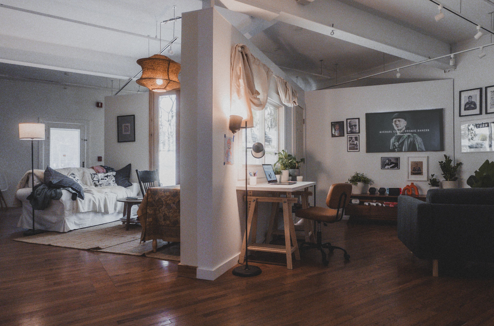 Wide view of the Media Diet installation, a gallery room staged like living rooms with multiple screens
